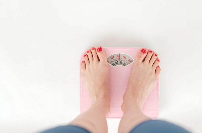 Maigrir ou manger autrement ? Le point sur votre diététique santéfemale measuring weight on scales on white background